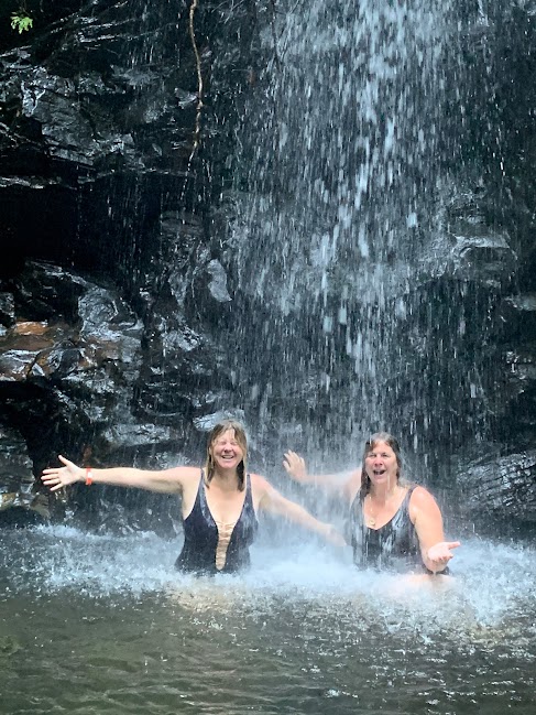 Amy and Sam under a waterfall at Barefoot Perfect Belize